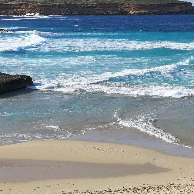 Waves rolling onto the sand at Cala Comte